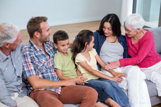Family sitting on sofa and interacting with each other in living room