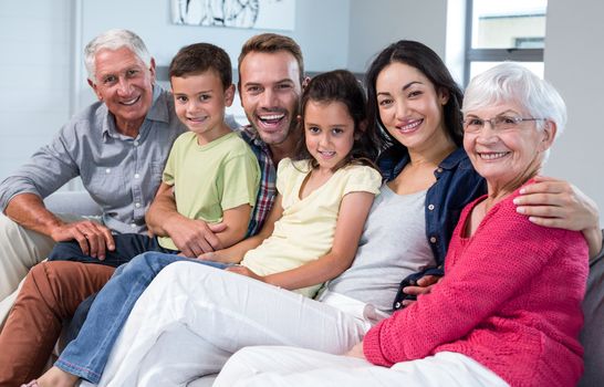 Portrait of family sitting on sofa and smiling in living room