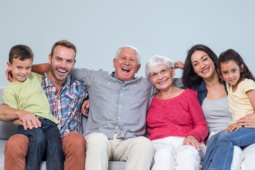 Portrait of family sitting on sofa and smiling in living room