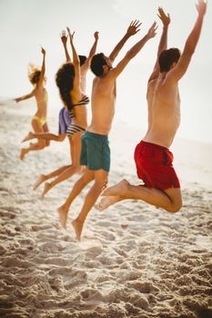 Friends jumping on the beach on a sunny day