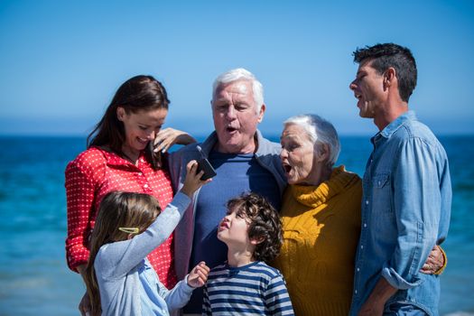 Happy family with a smartphone at the beach