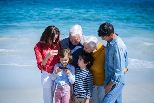 Happy family with a smartphone at the beach