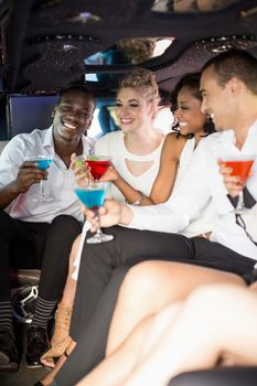 Well dressed people drinking cocktails in a limousine on a night out