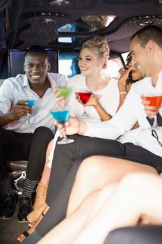 Well dressed people drinking cocktails in a limousine on a night out