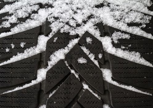Close up of an old tire half covered in snow
