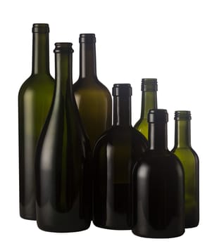 Horizontal front view of a group of empty wine bottles of different sizes, shapes and colorisolated on white background.