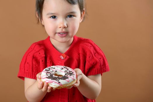 little girl holding donuts in studio