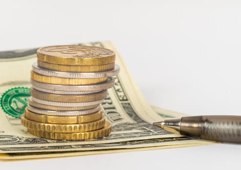 Stack of gold coins with pen on isolated white background