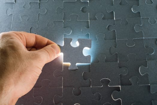 Man putting puzzle piece, close up view