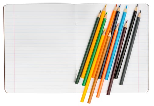 Open notebook with crayons on isolated white background, closeup