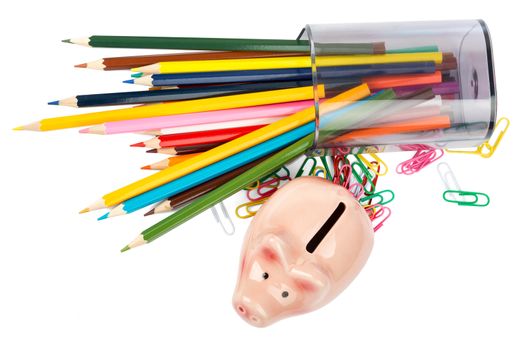 Piggy bank with crayons and paper clips on white background