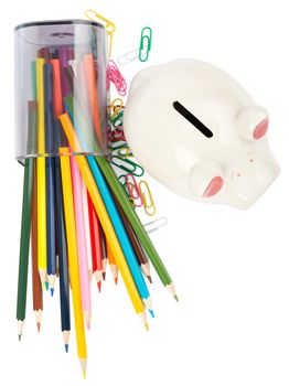 Piggy bank with colorful crayons and paper clips on white background