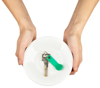 Female hands holding plate with keys on isolated white background