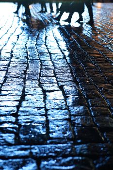 Night city. Closeup of wet cobblestone at night after rain