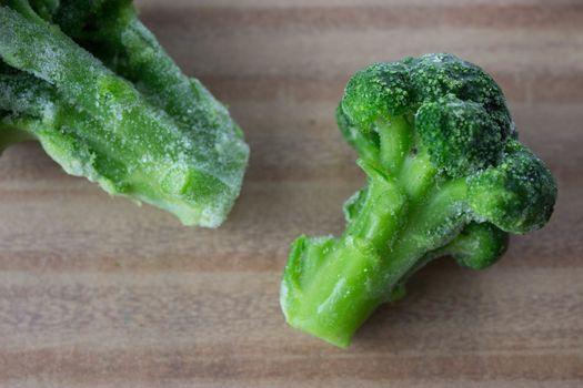 frozen, fresh green 
broccoli sprouts on wooden table