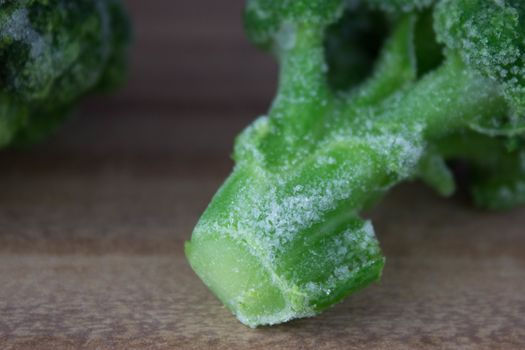 frozen, fresh green 
broccoli sprouts on wooden table