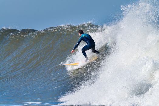 Surfer in action on the ocean waves on a sunny day.