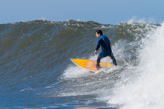 Surfer in action on the ocean waves on a sunny day.