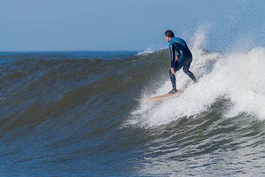 Surfer in action on the ocean waves on a sunny day.