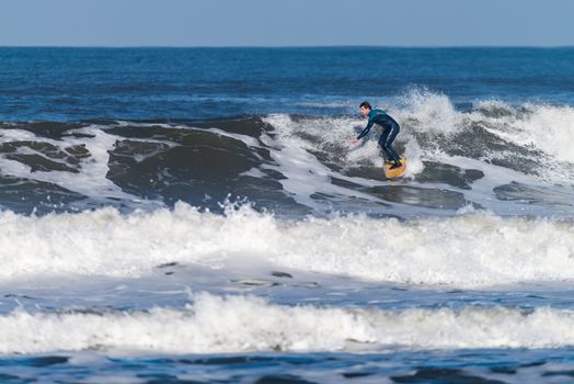 Surfer in action on the ocean waves on a sunny day.