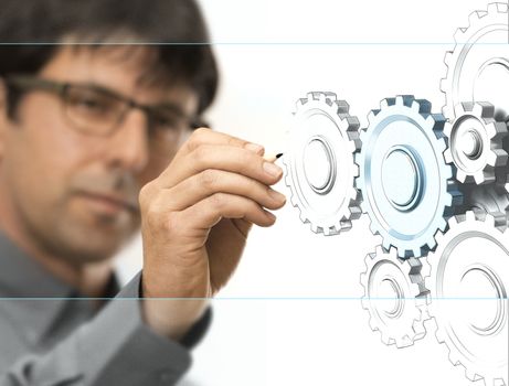 Caucasian engineer drawing gears on a transparent wall. Engineering background concept over white.