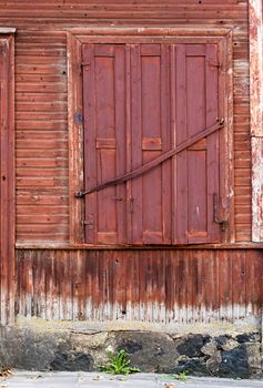 Window with closed shutters, wooden plank wallbackground