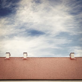 cloudy blue sky and tiled roof top background