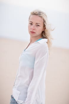 Beautiful sensual woman alone at beach. Melancholic vintage mood. Summer moved on.