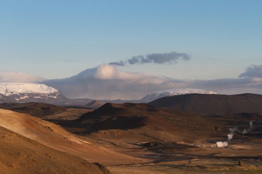 Horizontal panorama of the valley and the mountains covered in snow next to the Myvatn hot springs in Iceland
