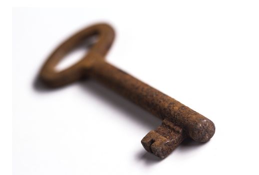 Old rusty key isolated on white background with shallow depth of field
