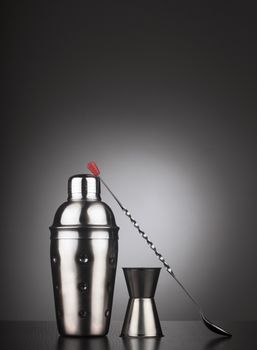 Set of cocktail tools with shaker and special spoon, vertical composition
