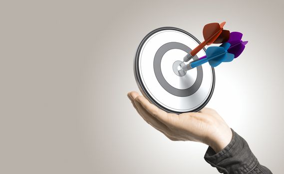 One hand holding a target with three darts hitting the center, beige background. Illustration of control and effective business solutions.