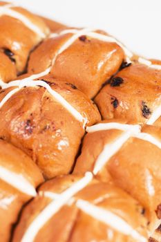 Hot cross buns on a timber board with a white background.