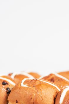 Hot cross buns on a timber board with a white background.