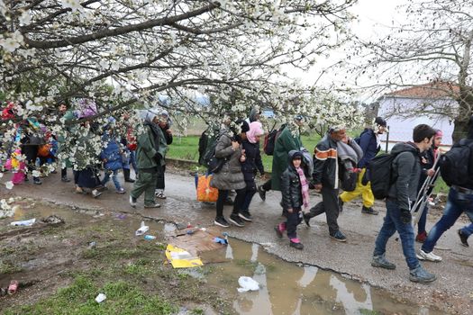 GREECE, Idomeni: Migrants and refugee cross a surging river on their way to Macedonia from a makeshift camp at the Greek-Macedonian border, near the Greek village of Idomeni on March 14, 2016, where thousands of them are stranded by the Balkan border blockade. More than 14,000 people are stuck on the Greek side of the border in an overcrowded camp at Idomeni after the main migrant route to western Europe through the Balkans was effectively shut down last week.