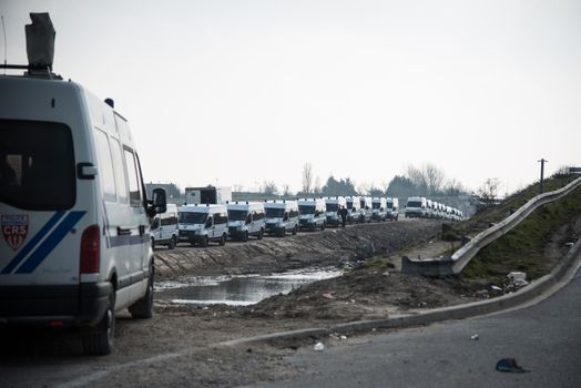 FRANCE, Calais: French anti-riot policemen stand guard during the dismantling of the southern part of the so-called 'Jungle' migrant camp in Calais, northern France, on March 14, 2016.Thousands of migrants have been living in the Jungle and other smaller camps along the northern coast, desperate to reach Britain where many have family or community ties and see better hopes of gaining employment or education. 