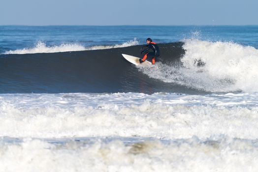 Surfer in action on the ocean waves on a sunny day.