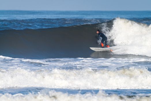 Surfer in action on the ocean waves on a sunny day.