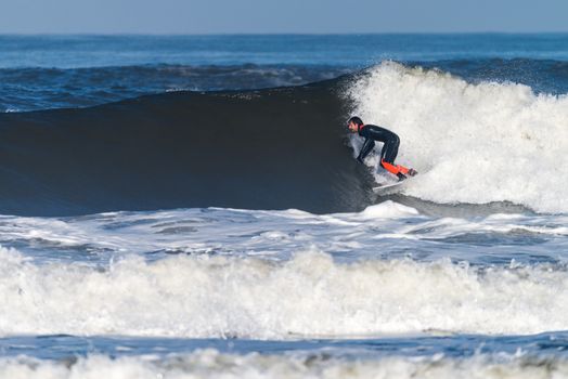 Surfer in action on the ocean waves on a sunny day.