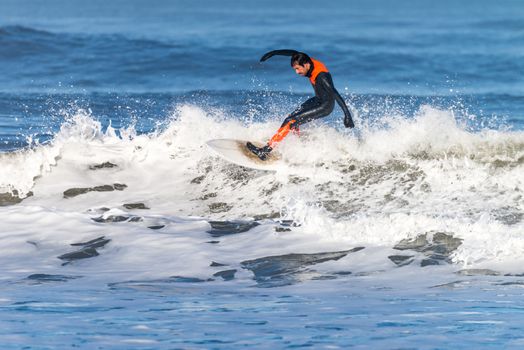 Surfer in action on the ocean waves on a sunny day.