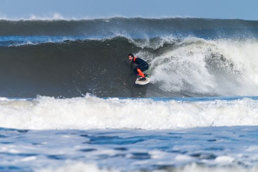 Surfer in action on the ocean waves on a sunny day.