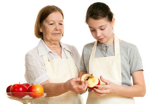 the grandmother teaches the granddaughter to cut off a peel from apple on a white background