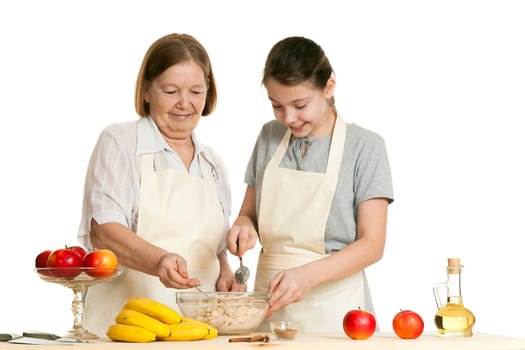 the grandmother and the granddaughter fill ingredients in a bowl on a white background