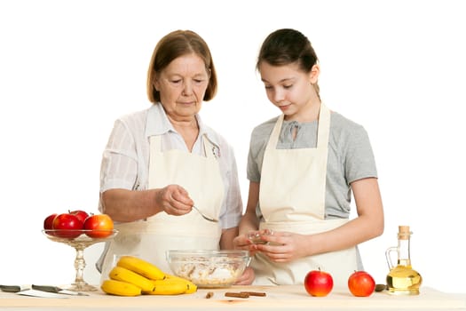 the grandmother and the granddaughter fill ingredients in a bowl on a white background