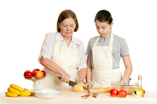 the grandmother and the granddaughter cut dough on a table on a white background