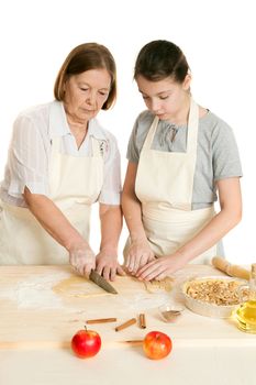 the grandmother and the granddaughter knife dough on a wooden board