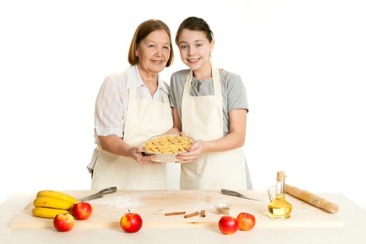 the grandmother and the granddaughter hold beautiful pie in hand