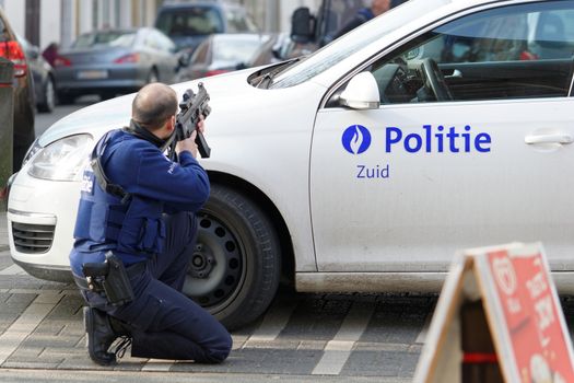 BELGIUM, Brussels: A police officer takes aim at the site of a shooting on Dries-Driesstraat at Forest-Vorst, in Brussels, on March 15, 2016. Shots were fired at Belgian police in the capital Brussels as they carried out an operation linked to the Paris attacks, Belgian prosecutors told.