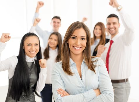 Successful young businesswoman standing proudly with her young business team and looking at the camera.