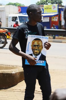UGANDA, Kampala: A supporter of former Uganda's presidential candidate and opposition leader Kizza Besigye is seen holding his portrait, during the Free my vote campaign launch in Kampala, on March 15, 2016. The Free my vote campaign, that includes praying every Tuesday around the country, is organized by the FDC (Forum for Democratic Change) in protest of the outcome of the February 18 presidential election and the subsequent home detention of the party's presidential candidate Dr Kizza Besigye who has been under police siege since the declaration of presidential results.